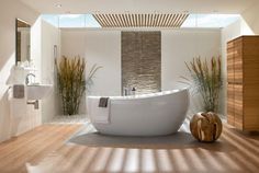 a white bath tub sitting on top of a wooden floor