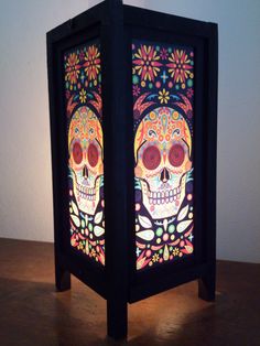 a lit up box with a skull and flowers on the front is sitting on a table