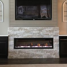 a living room with a fireplace and tv mounted on the wall