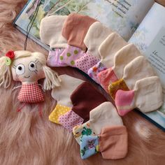 an open book on a furry surface next to some socks and a stuffed animal toy