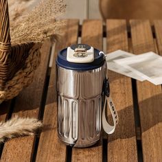 a metal trash can sitting on top of a wooden table