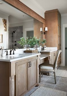 a large bathroom with two sinks and a mirror above the sink is surrounded by wooden cabinetry