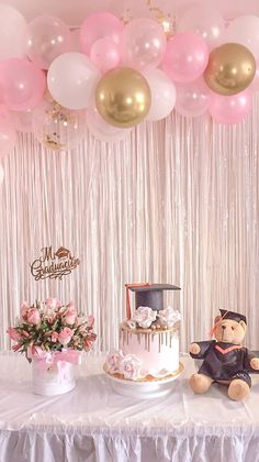 a table topped with a cake and balloons