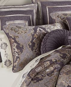 a bed covered in purple and gold pillows