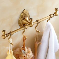 two towels are hanging on the wall next to a towel rack with three soaps and an umbrella