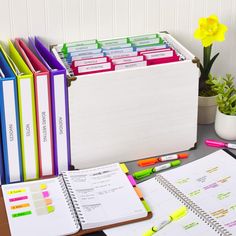 several binders and notebooks on a desk with flowers