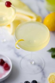 two martini glasses filled with lemonade and garnished with a slice of lemon