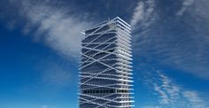 a very tall white building sitting on top of a lush green field under a blue sky