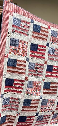 a red, white and blue quilt hanging from a window