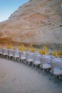 tables and chairs set up in front of a cliff