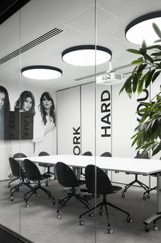 an office meeting room with white tables and black chairs