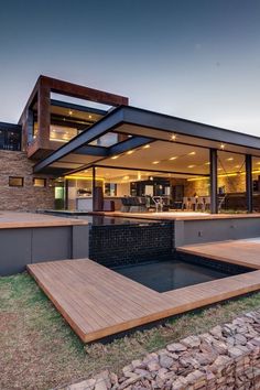 a modern house with wooden decking and glass walls