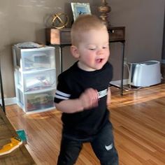 a little boy that is standing up on a hard wood floor