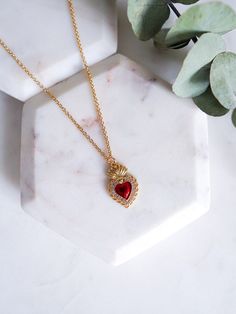 "The Sacred Heart is used to symbolize the divine love of Jesus, healing & gratitude. Our Sacred heart necklace features a dainty gold filled red and gold mexican milagro heart charm set on an 18k gold filled chain dainty and perfect for everyday. Give as a gift for Mother's Day, Birthday, Valentines Day or any Religious ceremony.  LINK TO MATCHING SACRED HEART EARRINGS: https://www.etsy.com/listing/1643055230/sacred-heart-earrings-red-flaming-heart - 18K gold filled milagro heart pendant - 18K gold filled 18\" satellite chain CARE: GOLD FILLED JEWELRY In order to prolong the life of your jewelry avoid exposing them to lotions, perfumes, or harsh chemicals. Do not exercise, swim, or shower with your jewelry. Each piece comes packaged in a sturdy sealed plastic bag that can be used to store Sacred Heart Jewelry, Jesus Healing, Latina Vibes, Milagro Heart, Sacred Heart Necklace, God Necklace, Flaming Heart, Red Heart Necklace, Sacred Heart Of Jesus