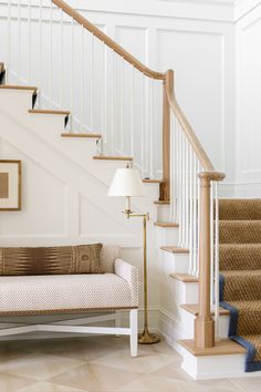 a living room filled with furniture and a stair case next to a bannister