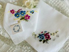 This is a vintage white linen lawn hankie embroidered with beautiful pink and blue pansies surrounded by petite white and yellow daisies.  Each corner features a single pink or blue pansy with tiny daisies.  Also included is a lavender scented sachet made from a freshly laundered hankie featuring a bouquet of embroidered pink and purple pansies that match the hankie.  The hankie measures 14 inches square, has a hand rolled hem, and is in excellent gift giving condition.  The sachet measures 5 1/ White Floral Embroidered Handkerchiefs For Gifts, Vintage Blue Handkerchiefs With Floral Embroidery, Pink Vintage Handkerchiefs With Floral Embroidery, Vintage Multicolor Spring Handkerchiefs, Pink Vintage Flower-shaped Handkerchief, Purple Pansy, Yellow Daisies, Scented Sachets, Lavender Buds