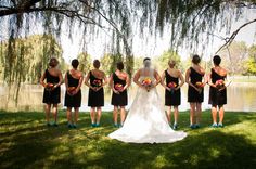 a bride and her bridal party standing in front of the water