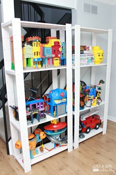 a white book shelf filled with toys on top of a wooden floor