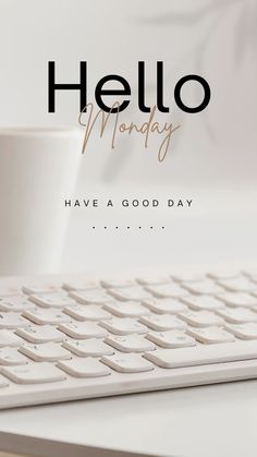 a white keyboard sitting on top of a desk next to a cup