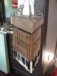 an old musical instrument is hanging from the ceiling in front of a kitchen sink and refrigerator