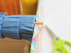 scissors are sitting on the table next to some folded up pieces of blue paper and other crafting supplies