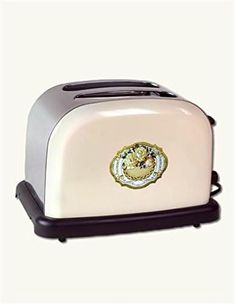 a white and black toaster with a gold emblem on the front is shown in this image