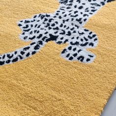 a yellow area rug with black and white animal print on the top, along with a gray floor