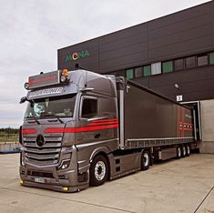 a large semi truck parked in front of a building