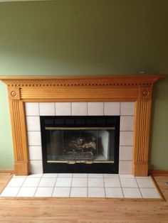 an empty fireplace in a living room with green walls