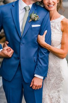 a man in a blue suit and woman in a white dress