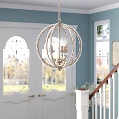 a chandelier hanging from the ceiling in a room with blue walls and white trim