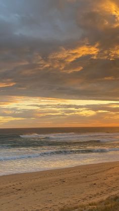 the sun is setting over the ocean and beach