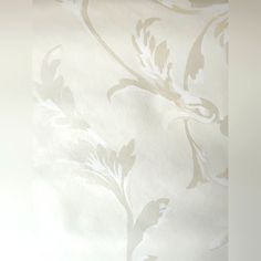 a vase with flowers on it sitting in front of a wallpapered window sill