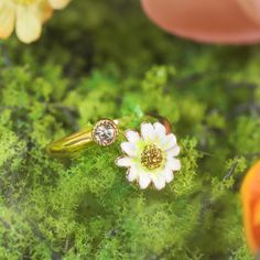 The Daisy Ring, with its open and adjustable design, feels like a delicate bloom resting upon your hand. Each petal is handcrafted in enamel, set upon 18K gold-plated brass, as though plucked straight from a morning garden. A sparkling cubic zirconia sits at the heart of the daisy, catching the light like morning dew. The adjustable band ensures a perfect fit, allowing this graceful flower to adorn any finger, bringing with it a timeless charm and a reminder of nature’s simple beauty. DETAILS Plating: 18K Gold Materials:   18K Gold on Brass, Enamel, Cubic Zirconia Size: Adjustable, 0.47"*0.67"(12mm*17mm) Weight: 3.5 g Dainty Gold Enamel Ring Gift, Gold Enamel Flower Ring For Anniversary, Yellow Gold Enamel Flower Ring Gift, Dainty Flower-shaped Enamel Jewelry, Delicate Adjustable Open Flower Ring, Dainty Adjustable Enamel Jewelry, Flower Shaped Enamel Ring As A Gift, Flower-shaped Enamel Ring As Gift, Flower-shaped Enamel Ring For Gift