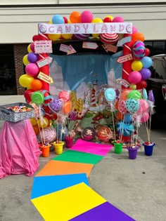 a candy land entrance decorated with balloons and streamers