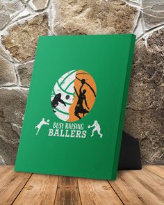 a green book sitting on top of a wooden table next to a stone wall with an image of a basketball player