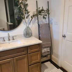 a bathroom with a sink, mirror and towel rack