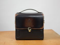 a brown and black bag sitting on top of a wooden table