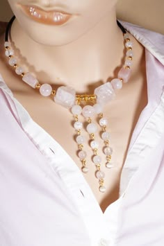 A beautiful necklace made with a lot of care and creativity from rose quartz, white crackled quartz, cat's eye and white agate beads. This unique piece is made of round and cuboid gemstones, with 2 uncut raw rose quartz gemstones in the center. For the glamorous appearance, the 3 strands of pearls are integrated in the center of the necklace and a deep neckline adorned with the piece of jewelry. All intermediate elements and lobster clasp in the back are gold plated with genuine 18K gold. The le White Rose Quartz Necklaces With Natural Stones, White Rose Quartz Necklaces For Healing, White Rose Quartz Necklace With Natural Stones, White Rose Quartz Necklace For Healing, White Rose Quartz Healing Necklace, White Rose Quartz Round Bead Necklaces, White Rose Quartz Necklaces With Gemstone Beads, White Rose Quartz Round Bead Necklace, Rose Quartz Gemstone Beads Crystal Necklace For Jewelry Making