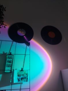 two record players are hanging on the wall in front of a mirror with light coming through it