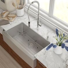 a stainless steel sink in a kitchen next to a window with blue flowers on it