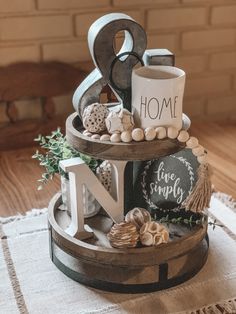 a three tiered tray with coffee mugs, cookies and other items on it