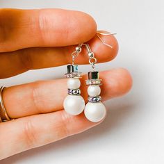 a pair of earrings with pearls and swarong crystals on the end of them