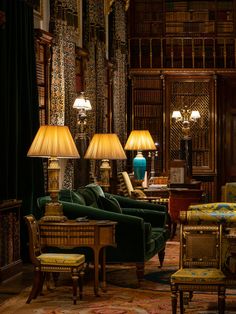 a living room filled with lots of furniture next to tall bookshelves and lamps