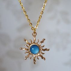 Make a statement with this pretty blue sun drop necklace for women. This cool quirky gold plated and acrylic blue sun necklace is a great way to add a nice touch to your outfit. The charm on this ladies sun necklace measures at 3cm x 2.7cm and is attached to a gold plated chain with lobster clasp. Various lengths of necklace chain are available, please select a length from the drop down menu. Please feel free to get in touch with us at Funky Earrings UK if you have any questions. We also have a wide range of other cute and unusual earrings and necklaces for her in our shop. Sun Aesthetic Outfit, Blue Accessories Aesthetic, Blue And Gold Aesthetic, Dratini Pokemon, Dnd Jewelry, Blue And Gold Necklace, Blue Gem Necklace, Sun Fashion, Petite Jewelry