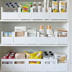 an organized pantry with white bins filled with food