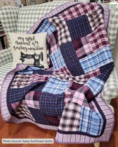 a blue and pink plaid blanket sitting on top of a chair next to a pillow