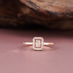 a diamond ring sitting on top of a pink surface