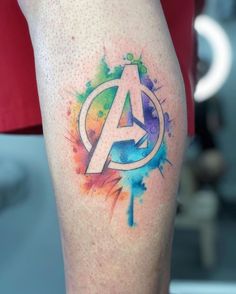 the avengers symbol is painted on someone's leg with paint splatters around it