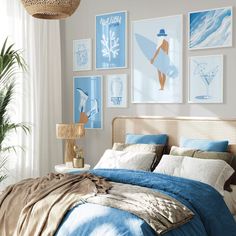 a bedroom with blue and white bedding, pictures on the wall and a wicker headboard